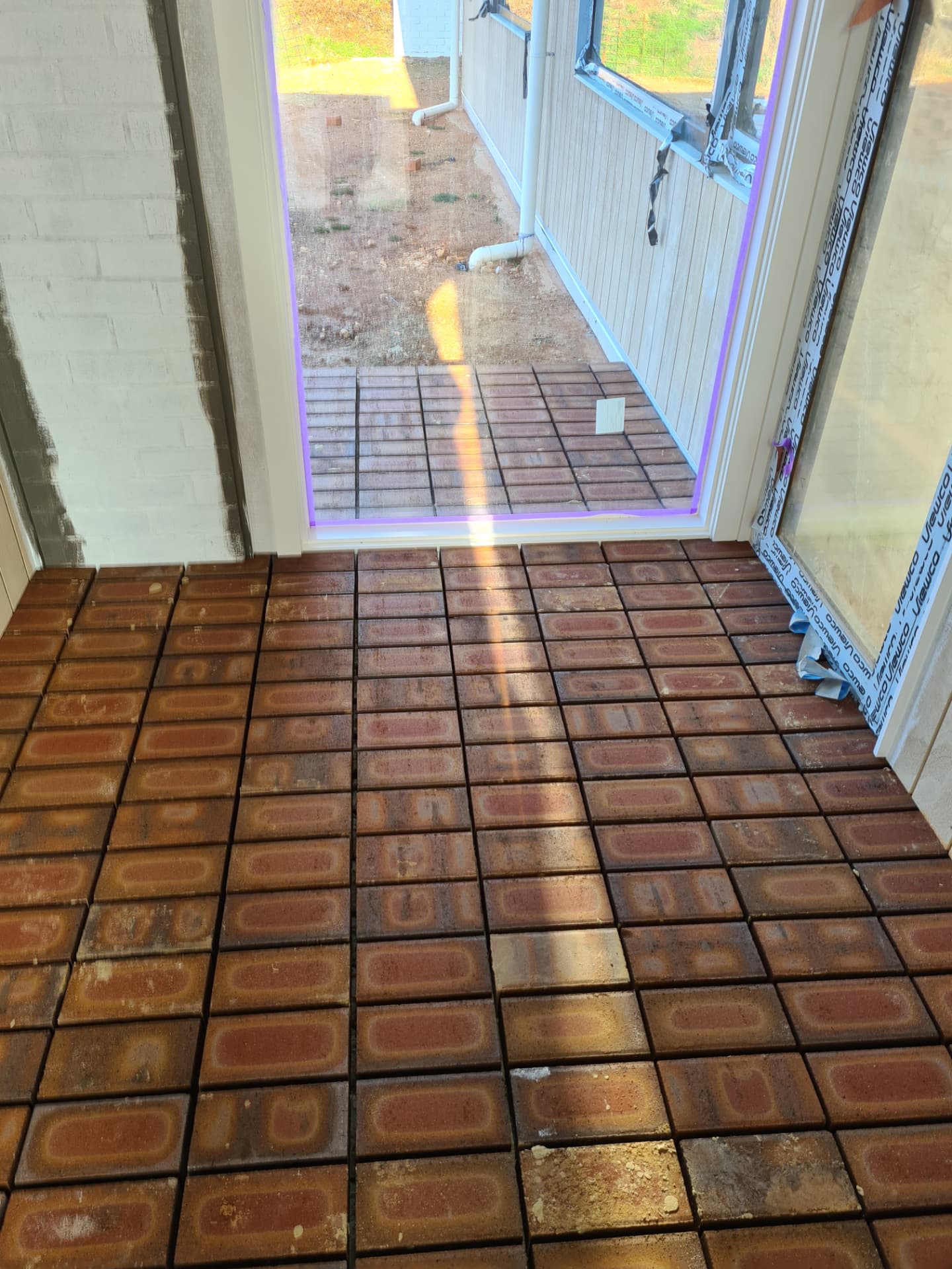 Clay brick pavers laid through a doorway to an outdoor alfresco area